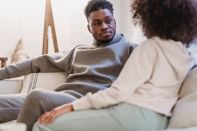 A couple having a calm, gentle conversation on the couch